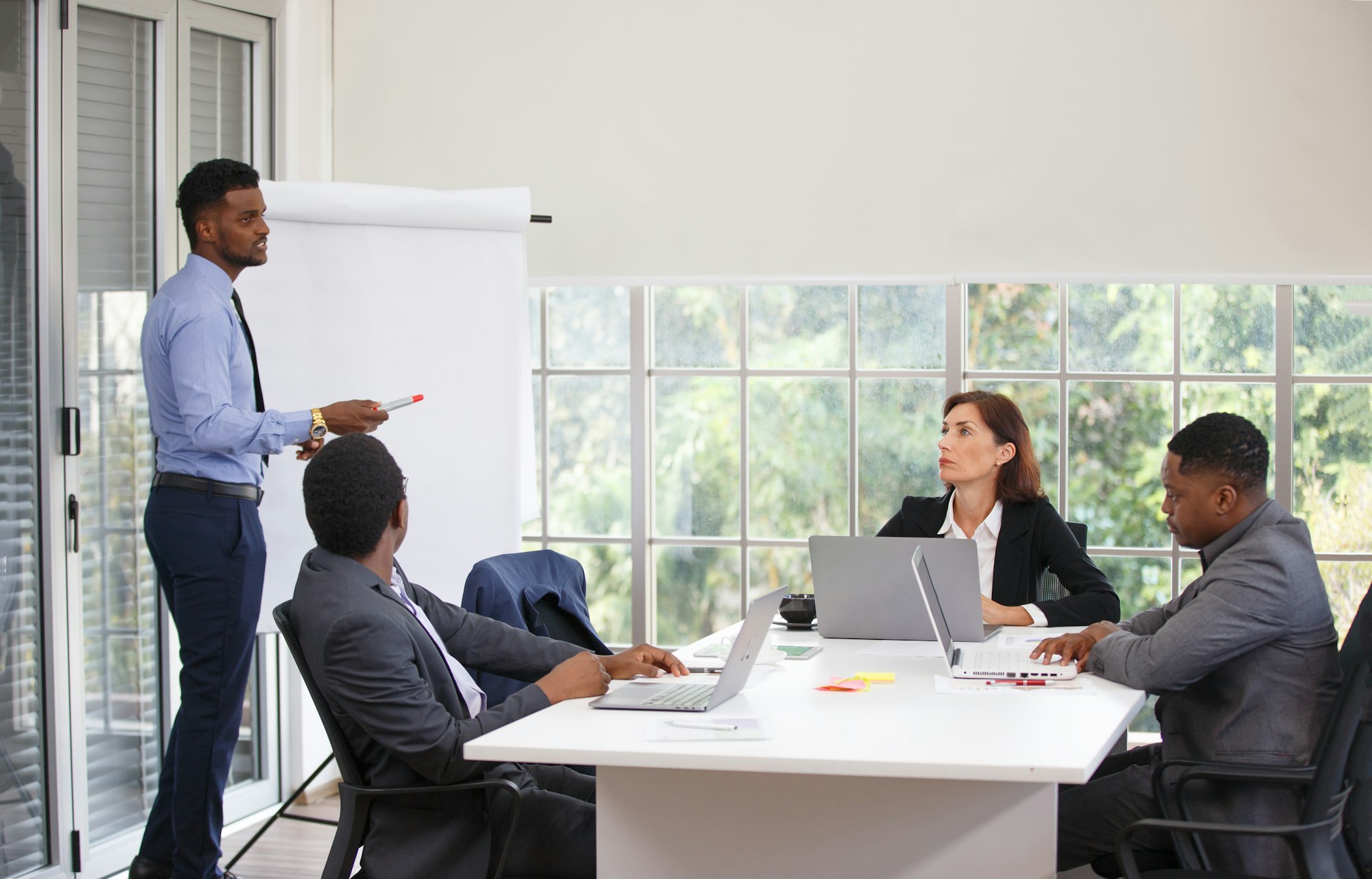 People at the office having a business meeting near an accountability board