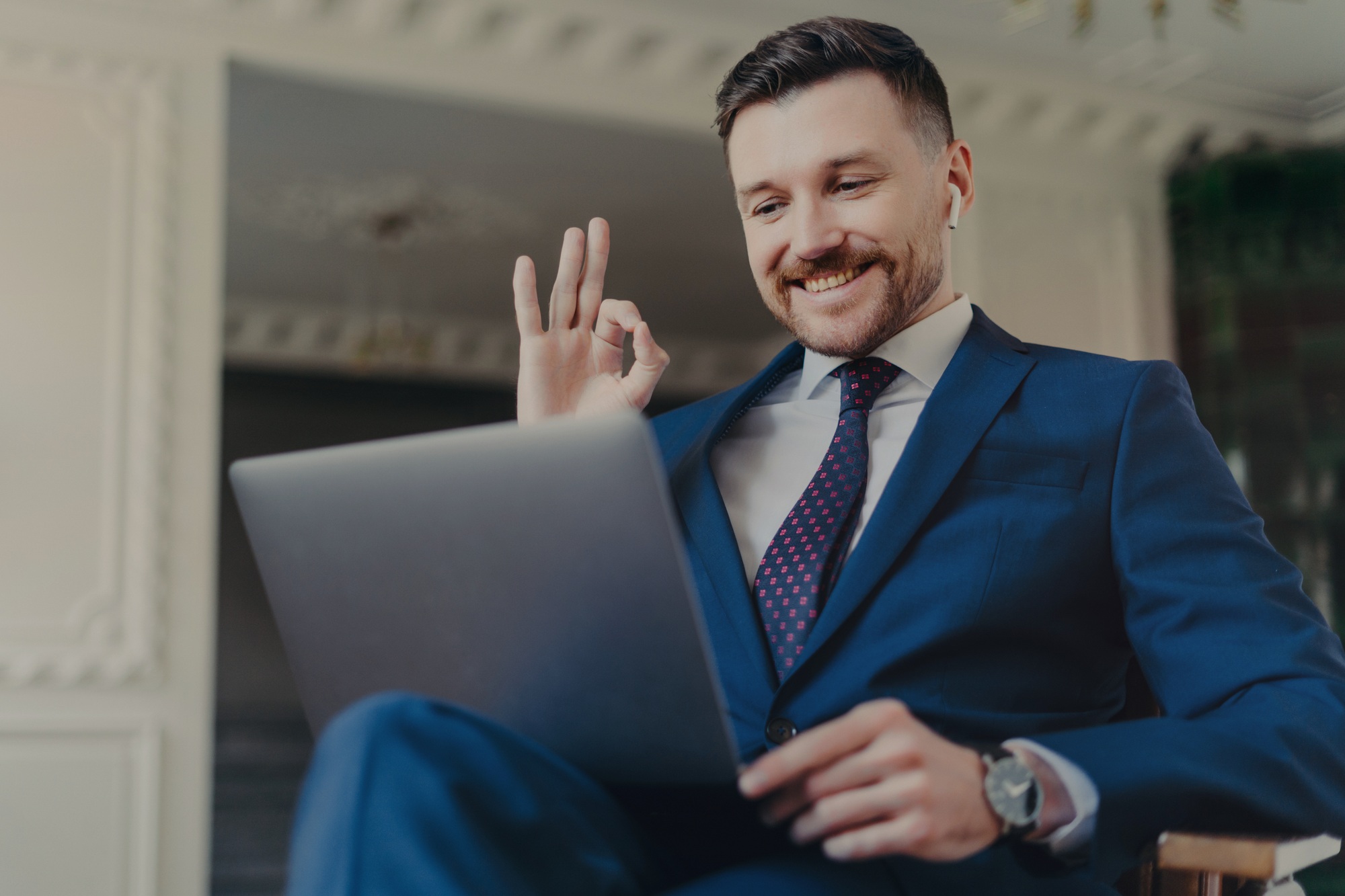 Cheerful businessman boss gesturing while communicating through video conference